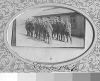 Frank with two rows of soldiers in front of an army hut [ jpeg ]